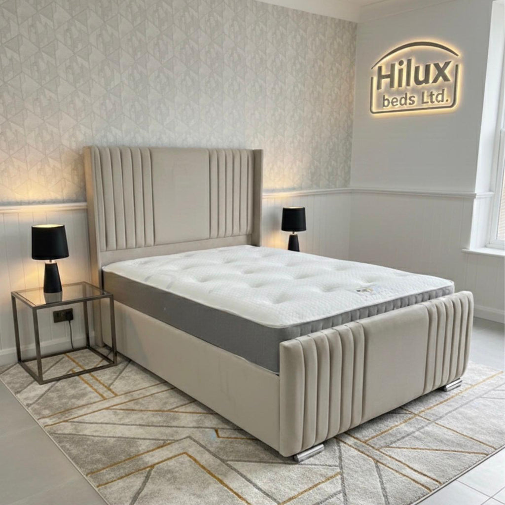 Beige upholstered bed in a modern bedroom with 'Hilux Beds Ltd' branding.