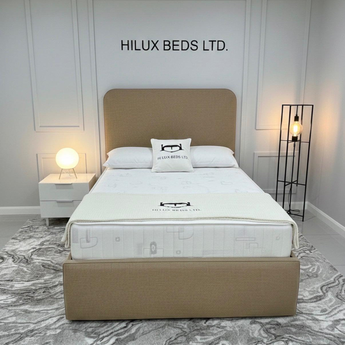 Person adjusting a bed in a bedroom with 'Hilux Beds Ltd.' branding.