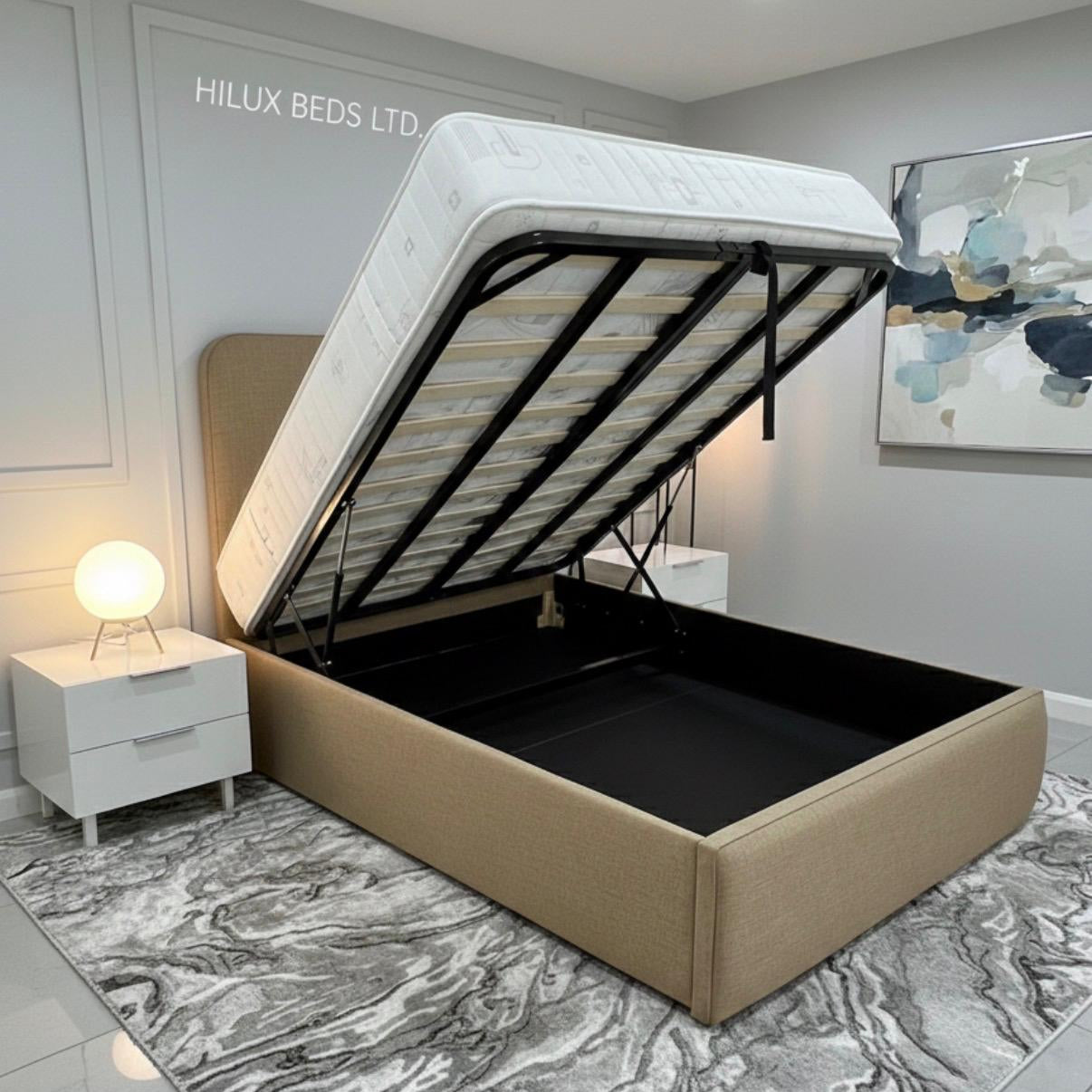 Beige bed with open storage compartment in a room with 'Hilux Beds Ltd' branding.