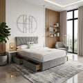 Modern bedroom with gray upholstered bed, side tables, and a large window.