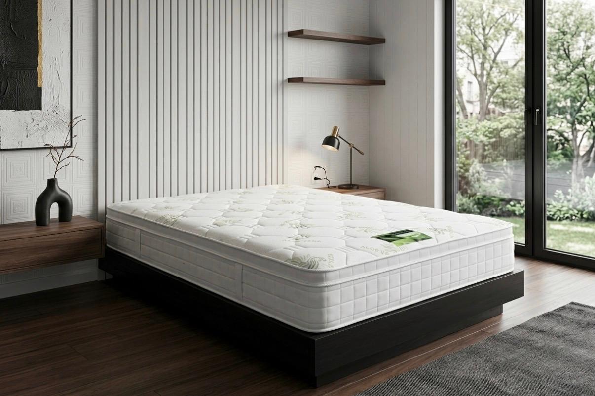 White mattress on a wooden bed frame in a modern bedroom with large windows.